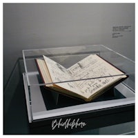 an open book on display in a glass case