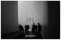 a black and white photo of people walking down a hallway