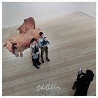 a family is taking a picture of a sculpture in an art museum
