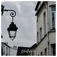 a street lamp with a cloudy sky in the background