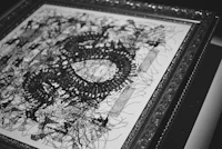 a black and white drawing of a dragon in a frame