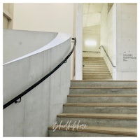 a staircase leading up to a building with a sign on it