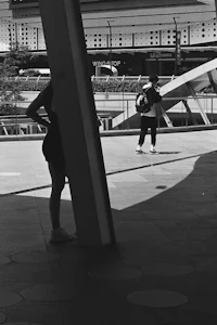 a black and white photo of a woman walking on a sidewalk