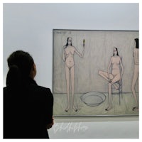 a woman looking at a painting of a woman and a man