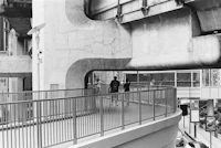 a black and white photo of people walking on a bridge