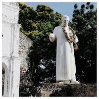 a statue of a man in front of a church