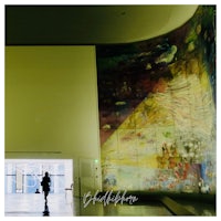a person walking in front of a large painting