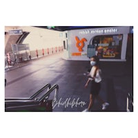 a woman wearing a face mask walking down an escalator