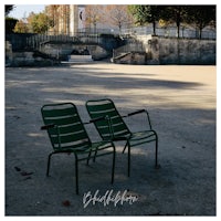two green chairs in front of a building