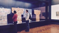 two people looking at a display of kimonos in a museum