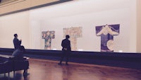 a group of people looking at a display of kimonos in a museum