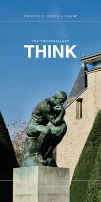 a statue of a thinker in front of a building