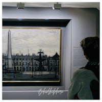 a woman is looking at a painting in a museum