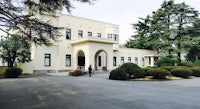 a large white house with bushes in front of it