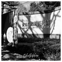 a black and white photo of a sign in front of a building