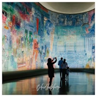 a group of people standing in front of a large mural