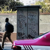 a pink phone booth with graffiti on it