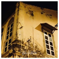 an old building with a clock on it at night