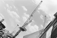 a black and white photo of a construction crane