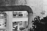 a black and white photo of a bridge over a street