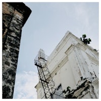 an old building with a ladder on top of it