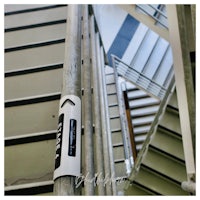 a metal stair railing with a sign on it