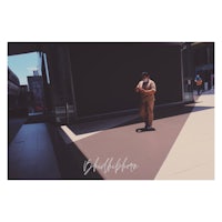 a man in a suit standing on a sidewalk