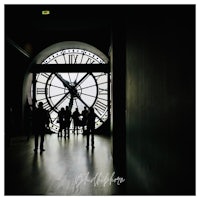 a group of people standing in front of a large clock