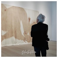 a woman looking at a painting in an art museum