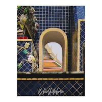 a blue and yellow tiled building with an archway