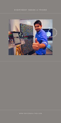 a man is standing in front of a computer screen with a thumbs up