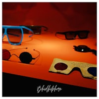 a group of glasses on a table with a red background