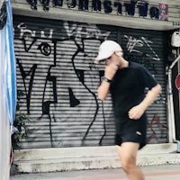 a man running past a building with graffiti on it