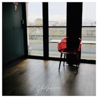 a red chair sits in front of a window