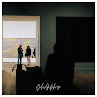 a group of people looking at paintings in an art museum